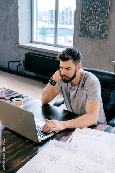 Fototapeta Serious businessman using laptop in office