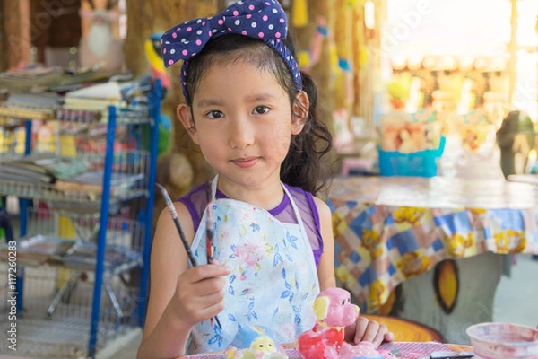 Fototapeta Cute asian girl show her paint brush.