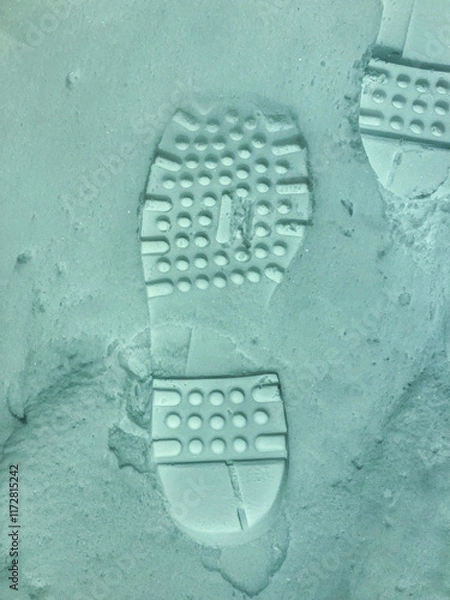Fototapeta The relief of a footprint on freshly fallen snow from the shoe of the left foot.