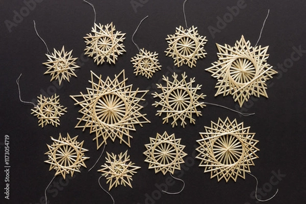 Obraz Snowflakes are made of straw on a black background. Christmas decor. Top view. Straw weaving. Lutsk, Ukraine