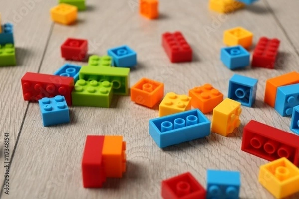 Fototapeta Construction toy. Colorful building bricks on wooden background, closeup