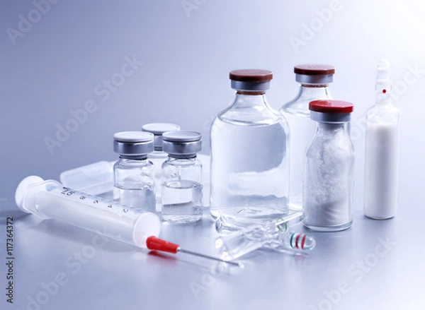 Fototapeta Vials and syringe, studio shot. Medical objects for vaccination. Vaccine drew up into a syringe. 