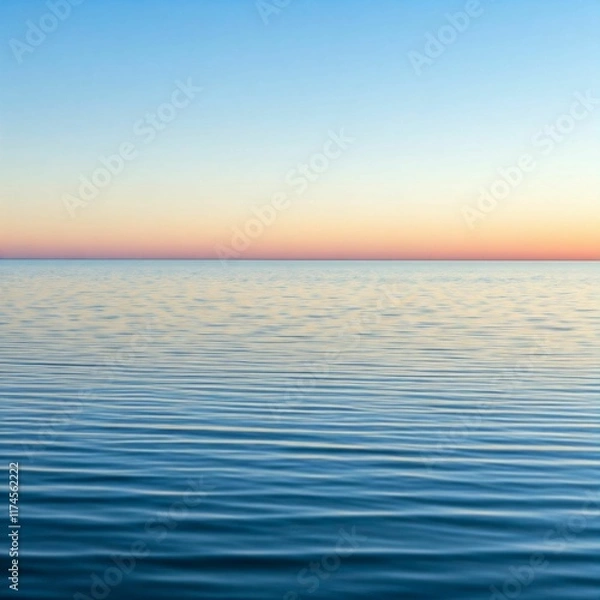 Fototapeta A smooth, calm ocean surface with soft ripples and light blue water, reflecting a pastel sky with a faint hint of the sun setting in the distance, ideal for serene and peaceful designs.