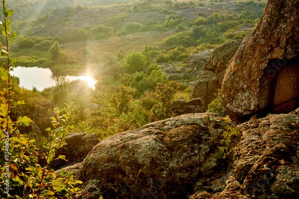Obraz Small lake with sun rays reflection in green valley