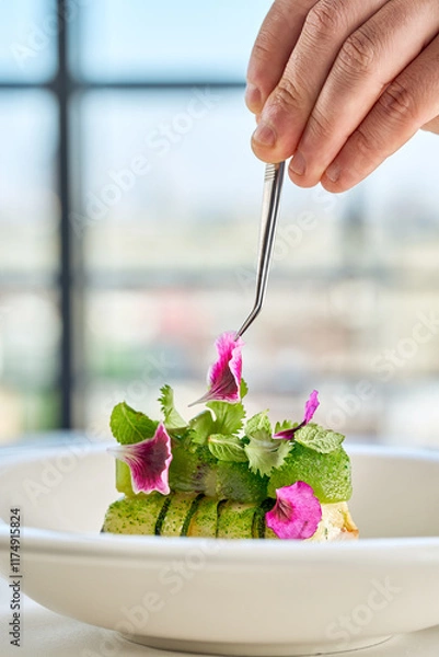 Fototapeta A gourmet dish featuring a delicate piece of fish, surrounded by a vibrant arrangement of fresh vegetables and edible flowers.