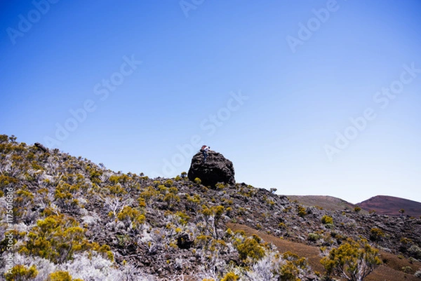 Fototapeta Man climbing a rock in Volcanic Terrain Reunion Island
