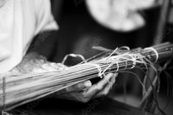 Fototapeta Black and white Old Man’s Hand Crafting a Traditional "Vouve" Tool for Catching Bichique