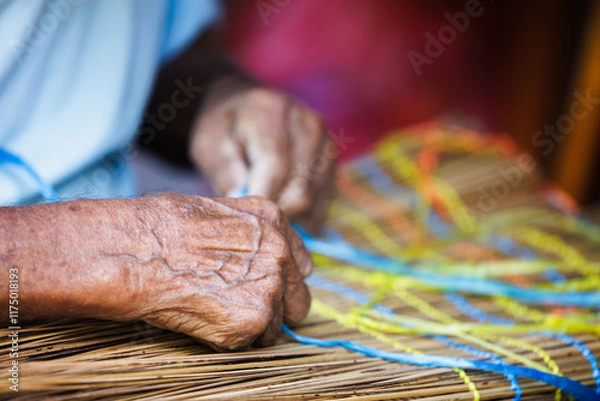 Fototapeta Old Man’s Hand Crafting a Traditional "Vouve" Tool for Catching Bichique