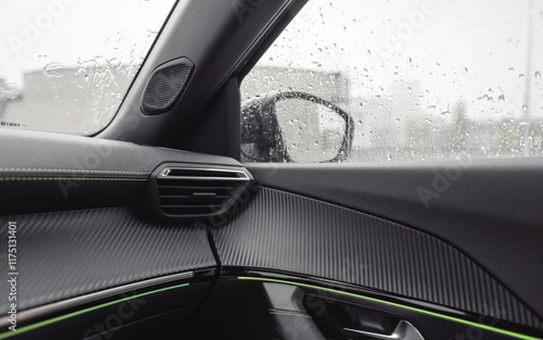 Obraz Sitting in car in a rain. Car door and dashboard with lime green trim elements. Cozy atmosphere and raindrops on widows. 