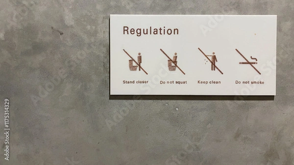 Fototapeta The warning sign on the toilet saying stand closer, do not squat, keep clean, and do not smoke on the toilet WC bathroom.
