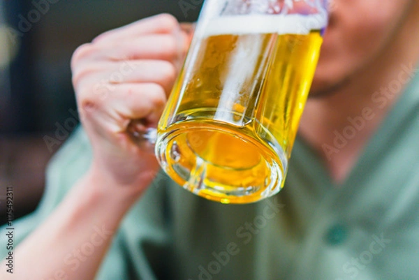 Obraz ジョッキでビールを飲む男性の手元
