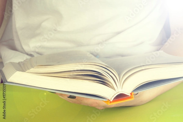 Fototapeta Young girl reading an open old book. Knowledge, Science. Toned image.
