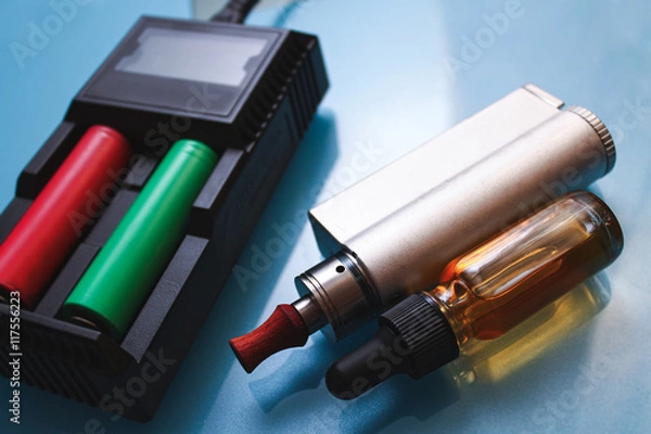 Obraz Electronic cigarettes,charger and bottles of liquid.