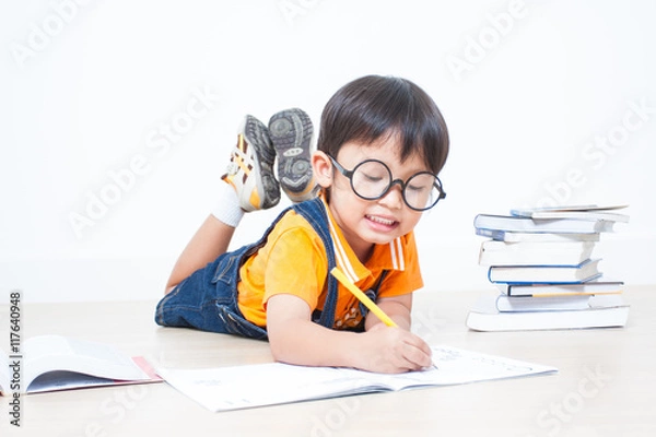 Fototapeta The boy writing homework from school in workbook 