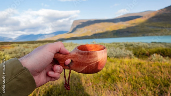 Obraz Enjoying coffee in traditional wooden crafted mug called kuksa in the middle of Lapland nature evokes beautifully spent time in the wilderness and enjoy friluft culture. Kungsleden trail, Sweden.