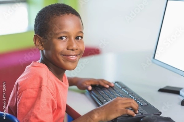 Fototapeta Schoolboy using computer in classroom