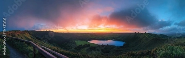 Fototapeta Panoramic view of an incredible vista with green hills and a colorful sky at sunrise