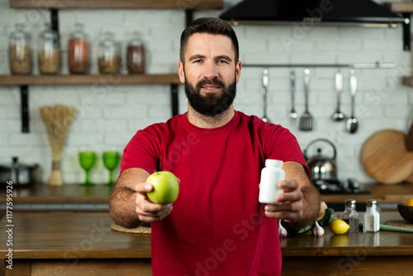 Fototapeta Young man choosing between an apple and bottle of pill, healthy dieting or nutritionist concept
