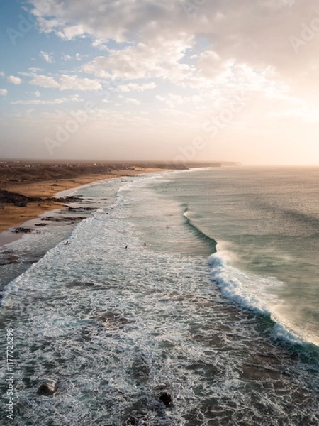 Fototapeta Vertical shot capturing a dramatic coastal scene with towering ocean waves
