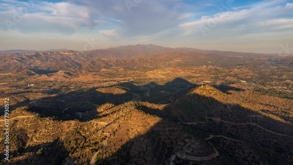 Obraz Aerial view of a mountainous landscape with cloud shadows.