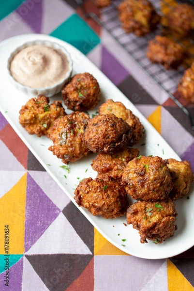 Obraz Bite-Sized Fried Eggplant Fritters Finger Food Appetizer with Dipping Sauce on a colorful geometric background
