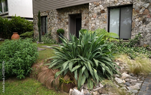 Fototapeta Architecture and landscaping. View of the private residence front yard and entrance facade built with steel framing and rock
