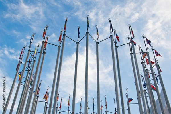 Fototapeta flags of different countries on background of sky with clouds