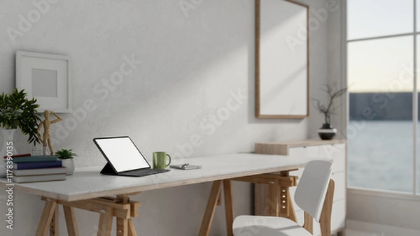Fototapeta A tablet and decorative items on a minimalist white table against a white wall in a simple home.