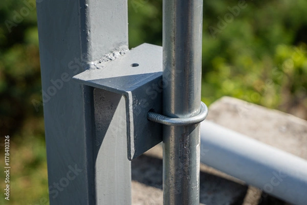 Fototapeta Use U-bolts to fasten the conduit pipe to the angle iron of the steel pole.