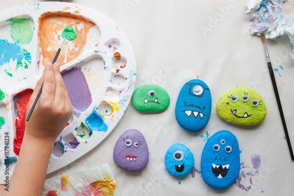 Fototapeta Child using paint for making stone monsters craft