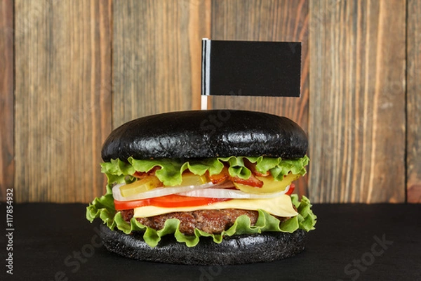 Obraz Black burger with flag on wood background