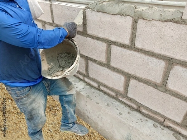 Fototapeta Construction worker install the concrete wall by using the plaster at the construction site area.