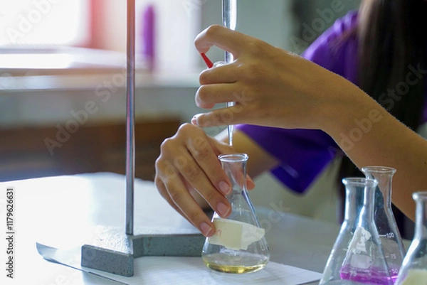 Obraz Close-up of a student performing an acid-base titration experiment. Concept of chemistry lab, science, experiment, skills, learning.