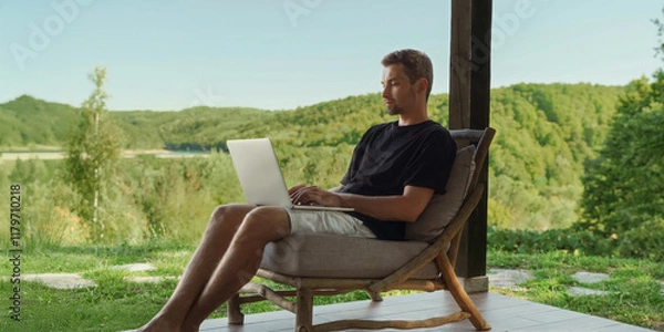 Obraz Freelancer works online on the terrace of a country house, enjoying nature and a beautiful forest view. Remote work and life balance. Space for text
