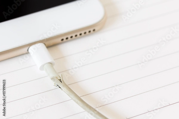 Obraz close up broken charger cable on spiral notebook