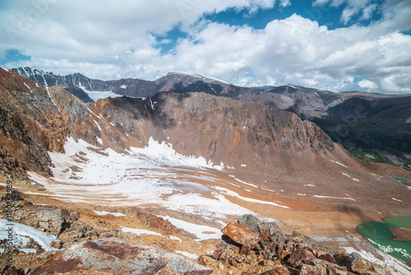 Fototapeta Vast top view from precipice edge to unusual beautiful glacier and glacial lake. Sharp rocky ridge and large mountain range in far away. Atmospheric layer landscape with big hills and high mountains.