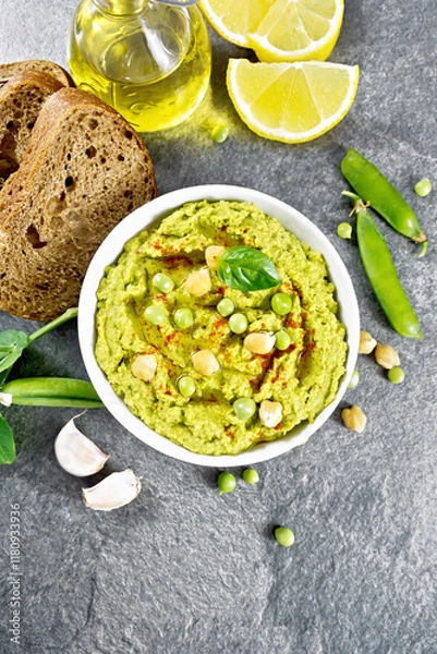 Obraz Hummus from green peas in bowl with bread on granite table top