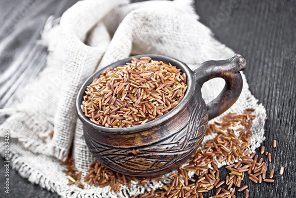 Obraz Rice red in cup on dark board
