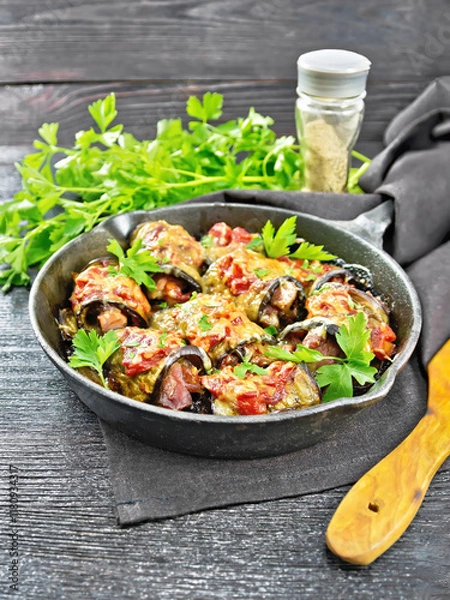 Obraz Rolls of eggplant with meat in pan on dark board