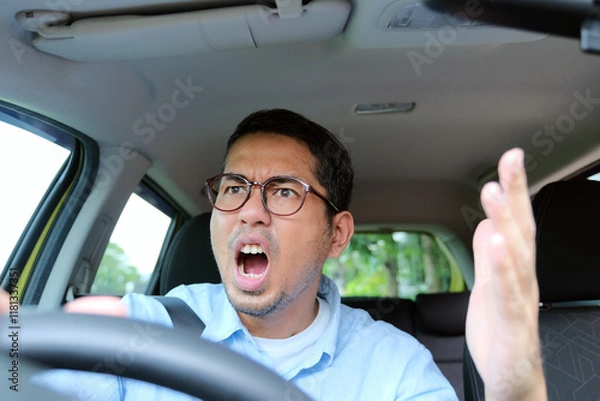 Fototapeta A car driver showing angry gesture when driving his car