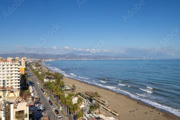 Fototapeta Aerial photo of the beach front in the Spanish town of Torremolinos in Spain showing the ocean beach front and hotels and apartments on the beach front on a sunny day