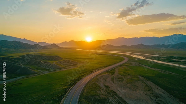 Obraz A scenic road winding through lush green fields at sunset