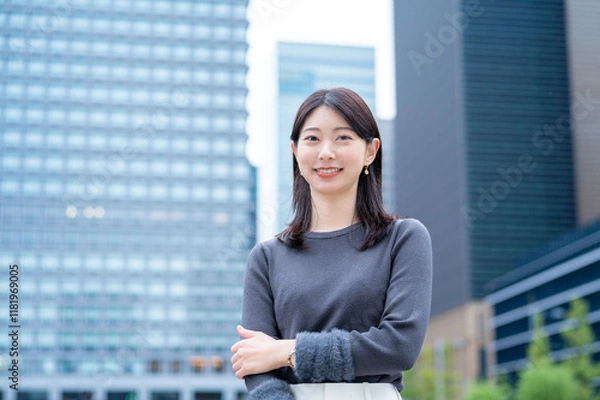 Obraz ビルを背景に笑顔の日本人女性