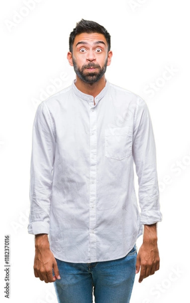 Fototapeta Adult hispanic man over isolated background puffing cheeks with funny face. Mouth inflated with air, crazy expression.