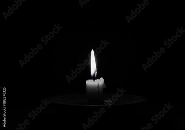 Fototapeta single candle flame, dark background, black and white photography, minimalist, dramatic lighting, contrast, solitude, reflection, atmospheric, moody, contemplative, shadows, simplicity, spiritual, med