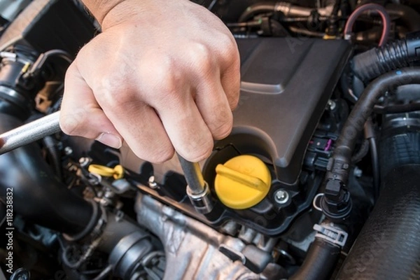 Fototapeta Hand repairing a modern car engine with a wrench