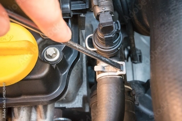Fototapeta Close up of a hose clamp check with a screwdriver