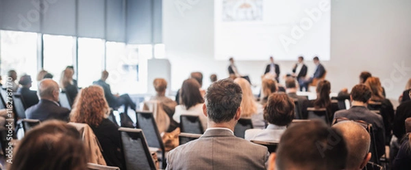 Fototapeta Interview and round table discussion at business convention and presentation. Audience at the conference hall. Business and entrepreneurship symposium.