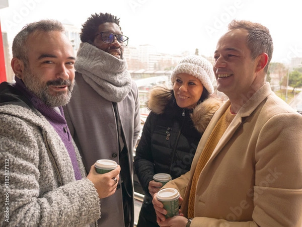 Fototapeta Four office workers on a coffee break in a business district. One looks at the camera with a confident expression, as if knowing something the others don t.