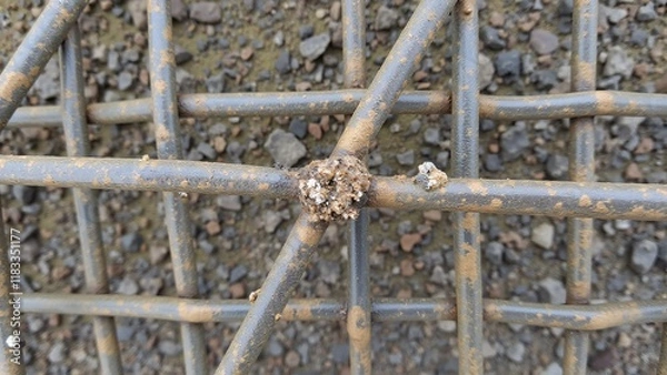 Obraz Worn metal grid surface, with dulled bars and rounded intersections showing signs of corrosion and stress, creating a rough, aged texture.